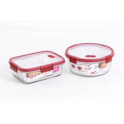 CURVER 'SMART COOK' 1,2L és 0,9L üveg tárolódobozok szett, piros szilikon fedéllel. Az edények hőtűrőek, ideális ételtárolásra, fehér háttér előtt elrendezve.