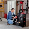 Kép 6/8 - Egy műhelyben elhelyezett KETER 6 fiókos tároló, fekete színben, fókuszban egy férfi, aki éppen szerszámokat rendszerez. A tároló forgó kerekeivel könnyen mozgatható, kiváló helytakarékos megoldás.