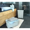 Kép 4/10 - Elegáns, rattan hatású CURVER 'STYLE' szennyestartó a fürdőszobában, 40 literes kapacitással. A kosár mellett törölközők és egy nyitott tároló edény található, világos színekben, modern környezetben.