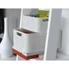 Kép 2/5 - Krémszínű CURVER 'STYLE' S méretű rattan kosár, mely tárolásra alkalmas, kettő egymásra rakott kosárral. A kosarak praktikusan fogantyúkkal ellátottak, a háttérben álló fehér polcon láthatók, magazinokkal kombinálva.