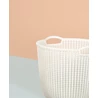 Kép 3/7 - Törtfehér, kerek CURVER 'KNIT' kosár, sima belső felülettel és stilizált kötött hatású oldalfalakkal, 30L űrtartalommal. A kosár modern környezetben, halvány árnyalatú háttér előtt látható.
